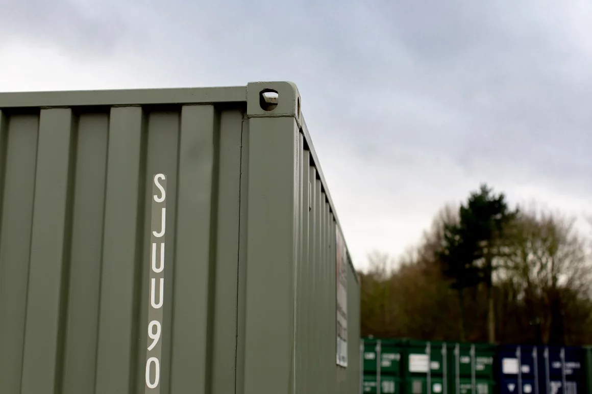 Green container corner with tree in background