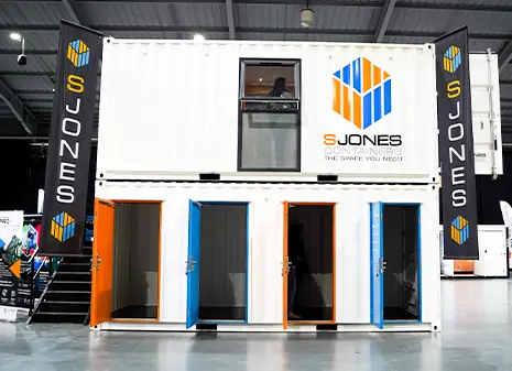 White multi store container with four personnel doors, displayed at the SSA exhibition with S Jones branding.