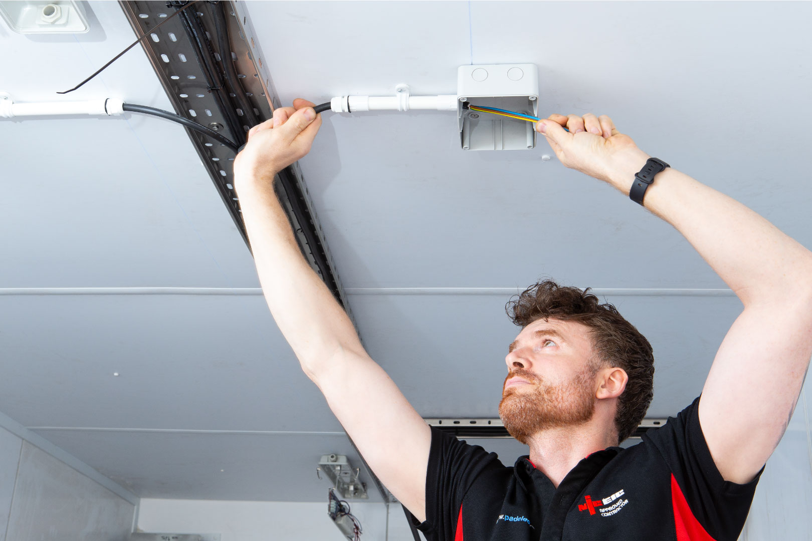 Electrician working to fit light in white container