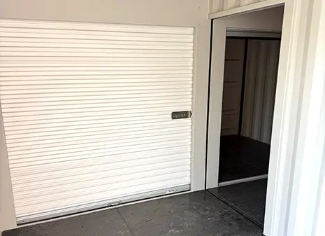 Close-up view of a white roller shutter unit inside a landing topper container, used for self storage access.